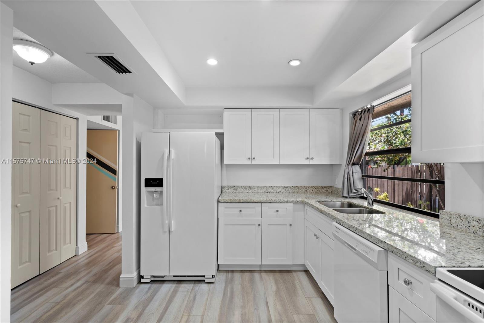 13298 Southwest 112th Terrace, Unit 461 Miami, FL 33186 - Photo 5 of 35 a kitchen with stainless steel appliances granite countertop a refrigerator and a stove top oven