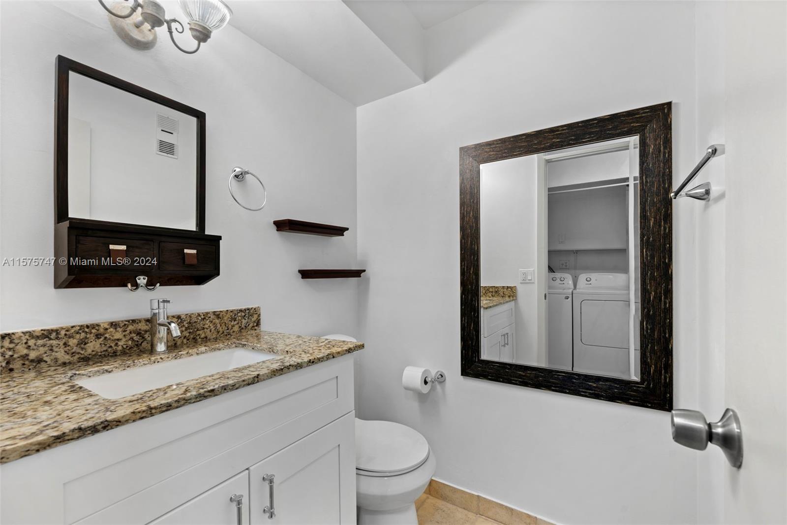 13298 Southwest 112th Terrace, Unit 461 Miami, FL 33186 - Photo 10 of 35 a bathroom with a granite countertop sink and a mirror