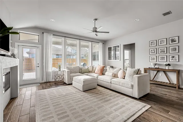 a living room with furniture a flat screen tv and a fireplace