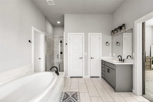 a spacious bathroom with a granite countertop sink a mirror a bathtub and a window