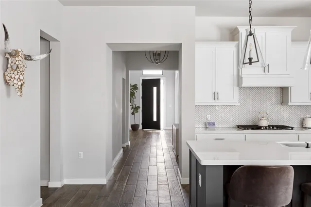 a view of a hallway with wooden floor and a potted plant