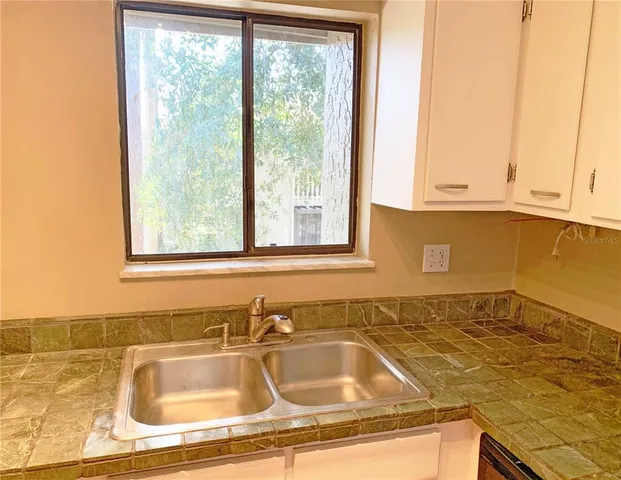 a bathroom with a granite countertop sink and a bathtub