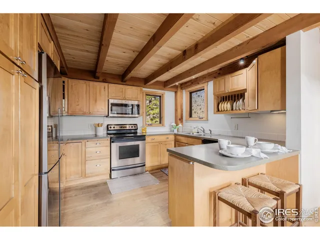 a kitchen with stainless steel appliances granite countertop a sink a stove and a refrigerator