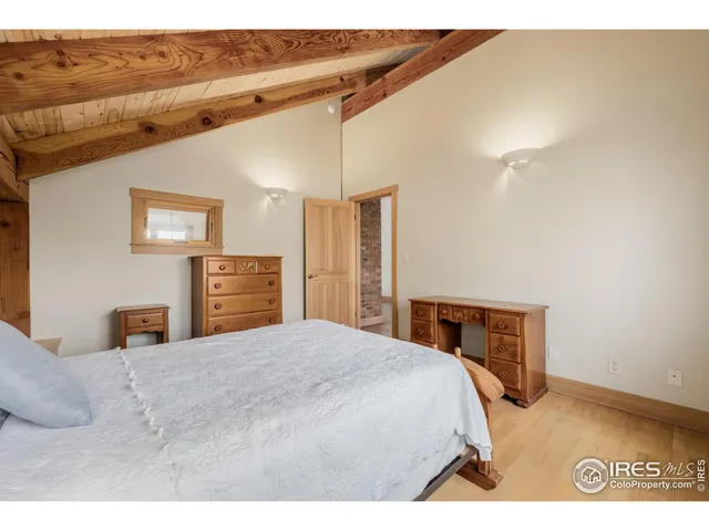 a bedroom with a large bed and a flat tv screen on dresser