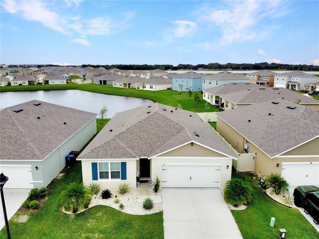 an aerial view of a house with a garden and lake view