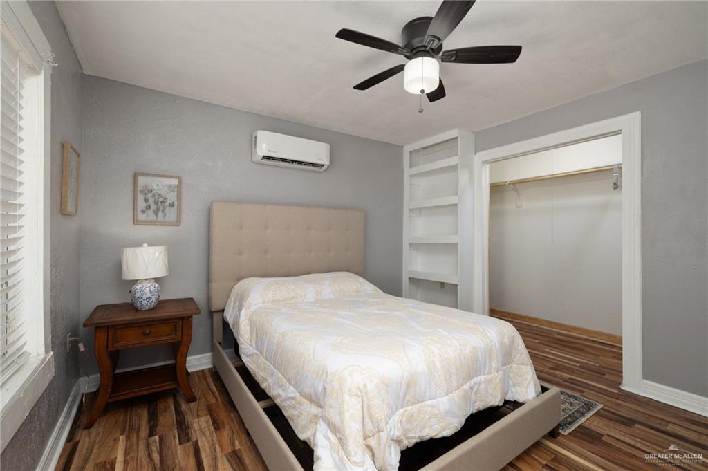 411 East 4th Street Rio Grande City, TX 78582 - Photo 7 of 12 Room featuring wood-finish flooring, a ceiling fan with integrated lighting, and a built-in shelving unit