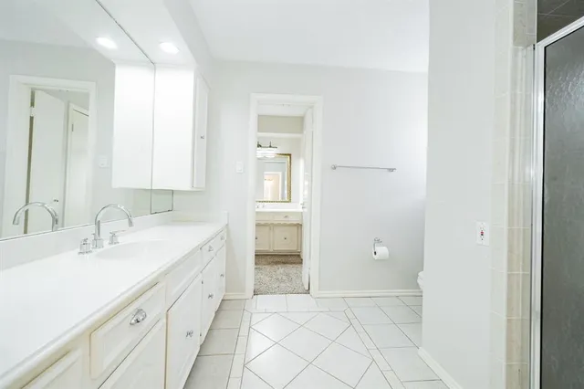 a spacious bathroom with a granite countertop sink and a mirror