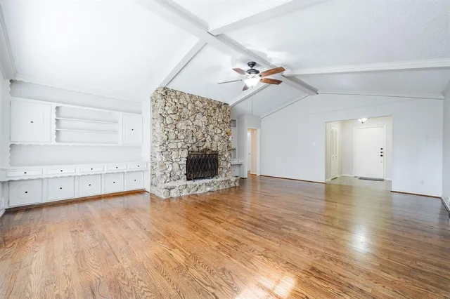 a view of empty room with wooden floor and fireplace