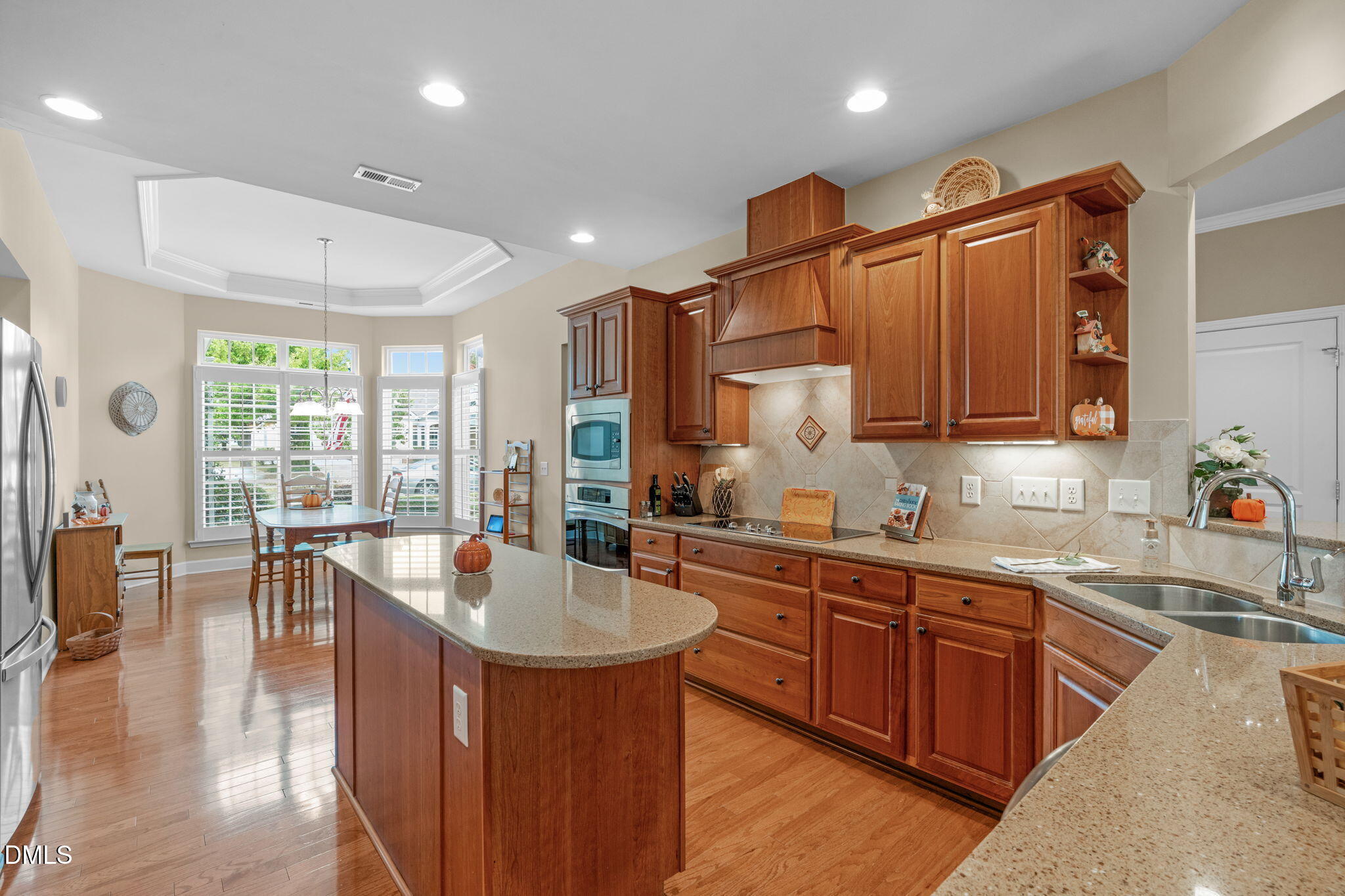 113 Beckingham Loop Cary, NC 27519 - Photo 21 of 57 a kitchen with stainless steel appliances granite countertop a sink dishwasher stove and wooden cabinets with wooden floor