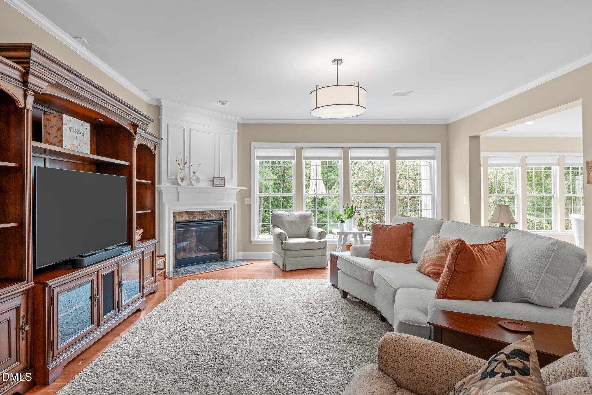 113 Beckingham Loop Cary, NC 27519 - Photo 10 of 57 a living room with furniture a flat screen tv and a floor to ceiling window