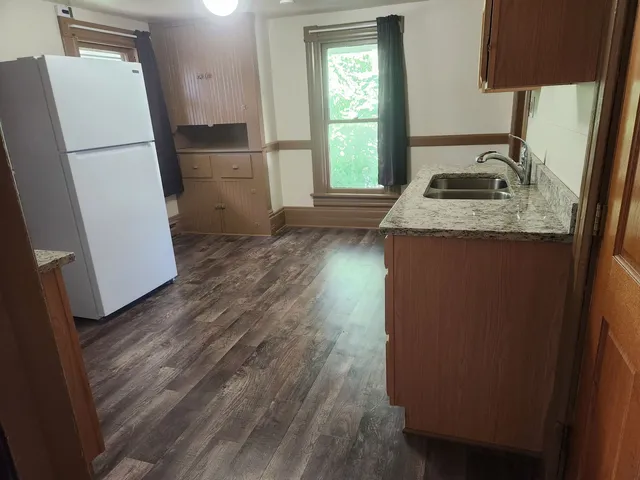 a kitchen with granite countertop a refrigerator and a sink