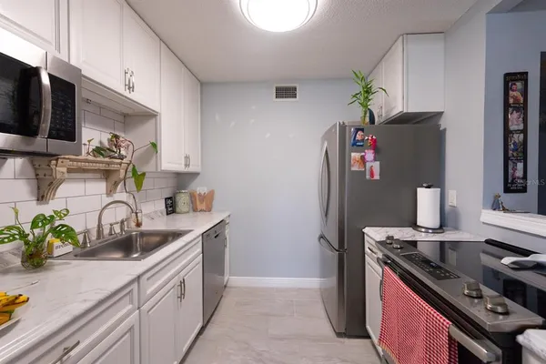 a kitchen with stainless steel appliances a sink cabinets and a stove