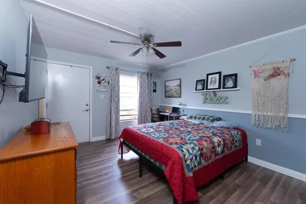 a bedroom with a bed and wooden floor