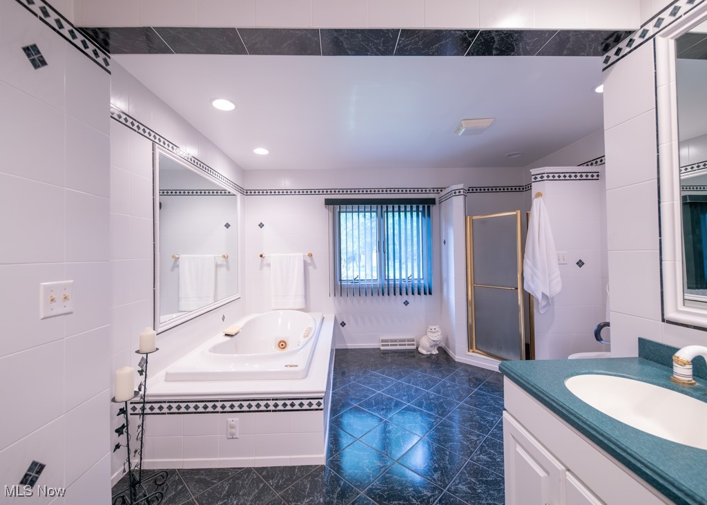 6652 Conley Road Ashtabula, OH 44004 - Photo 21 of 49 Master bathroom featuring vanity, tiled walk in shower with separate bathtub, and tile flooring