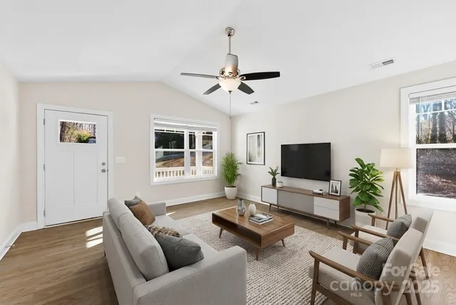 a view of a kitchen with a sink dishwasher a refrigerator with wooden floor and a chandelier