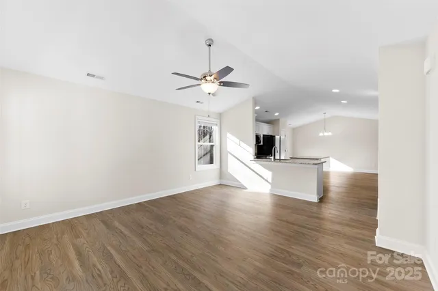 a view of a big room with wooden floor and a ceiling fan