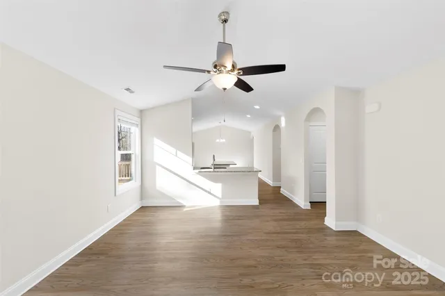 a kitchen with stainless steel appliances granite countertop a stove top oven a sink a dining table and chairs