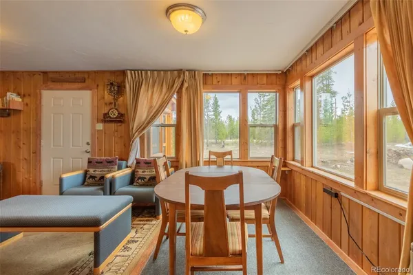 a dining room with furniture and a large window
