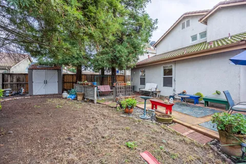 a view of backyard with outdoor seating and trees