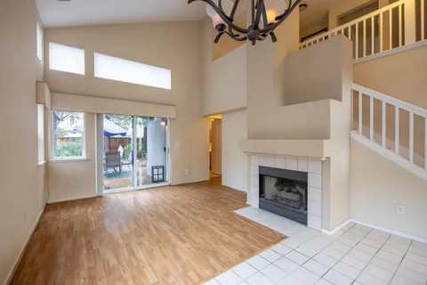 an empty room with windows and fireplace