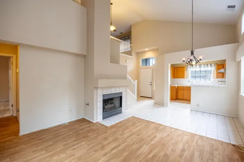 a view of empty room with wooden floor and fireplace
