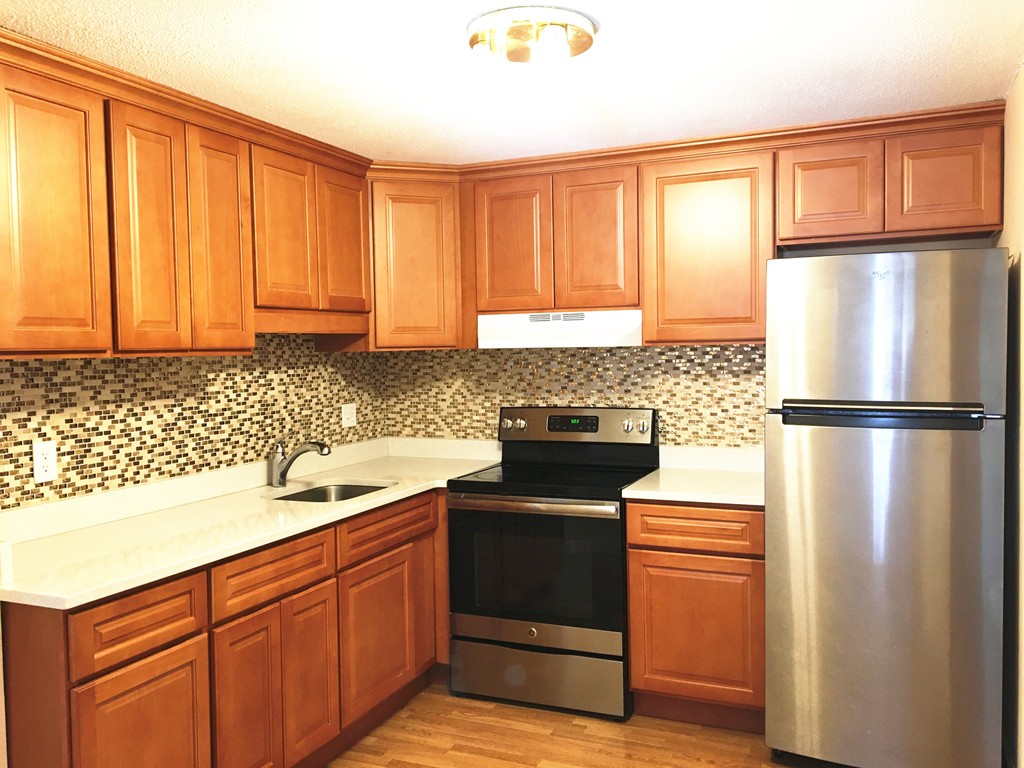388 Great Road, Unit B14 Acton, MA 01720 - Photo 5 of 14 a kitchen with a refrigerator sink and cabinets