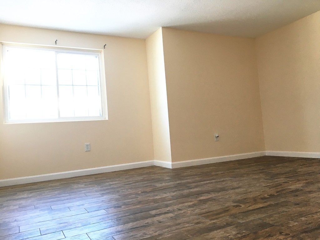 388 Great Road, Unit B14 Acton, MA 01720 - Photo 8 of 14 an empty room with wooden floor and windows