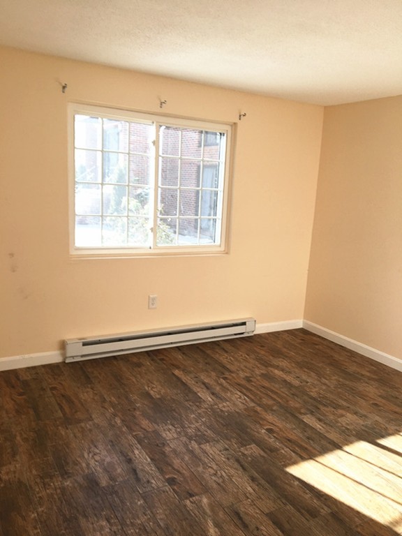 388 Great Road, Unit B14 Acton, MA 01720 - Photo 10 of 14 an empty room with wooden floor and windows