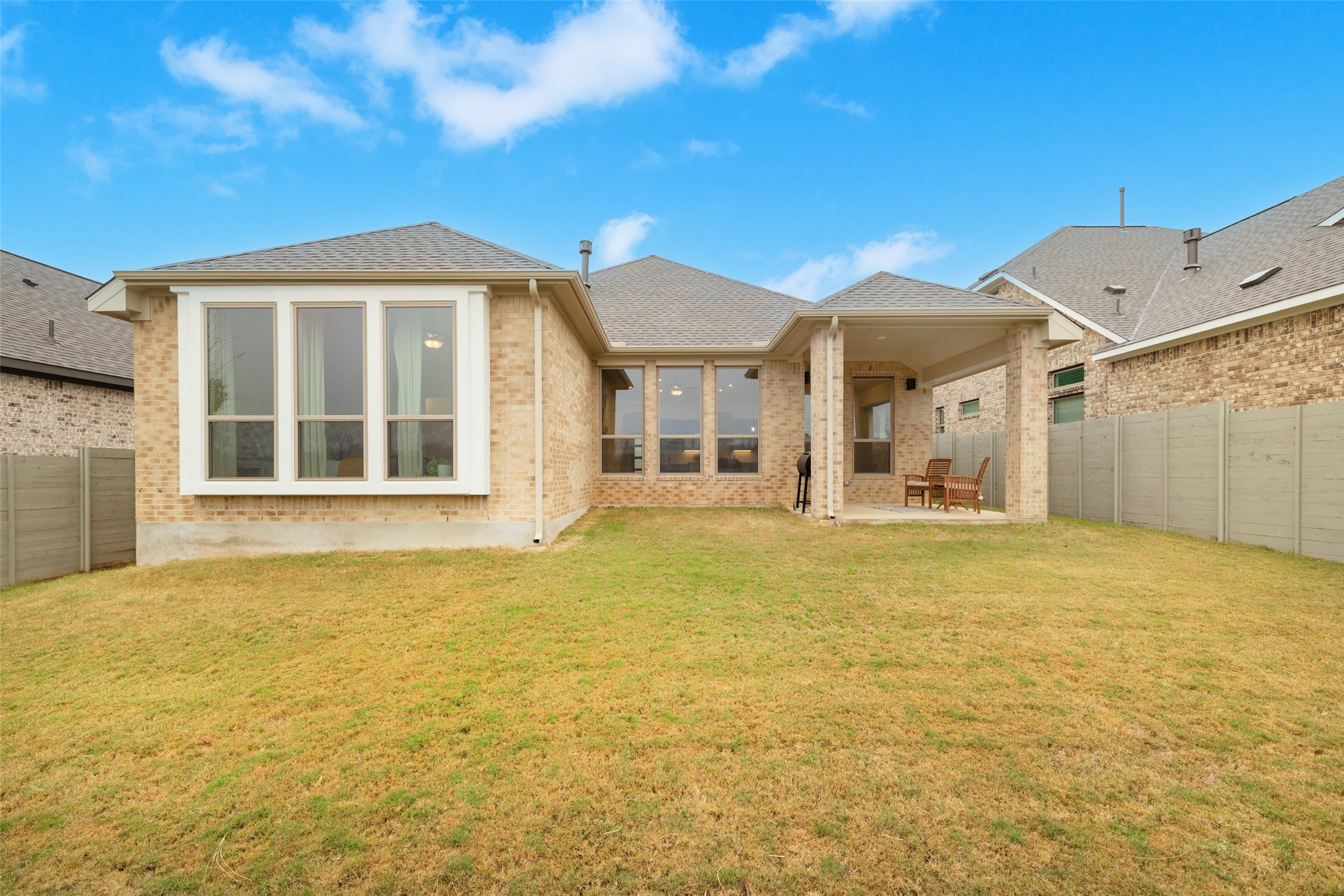 1117 Spring Gulch Lane Georgetown, TX 78628 - Photo 39 of 39 A generous lawn and a covered patio for outdoor enjoyment complement this charming brick residence.