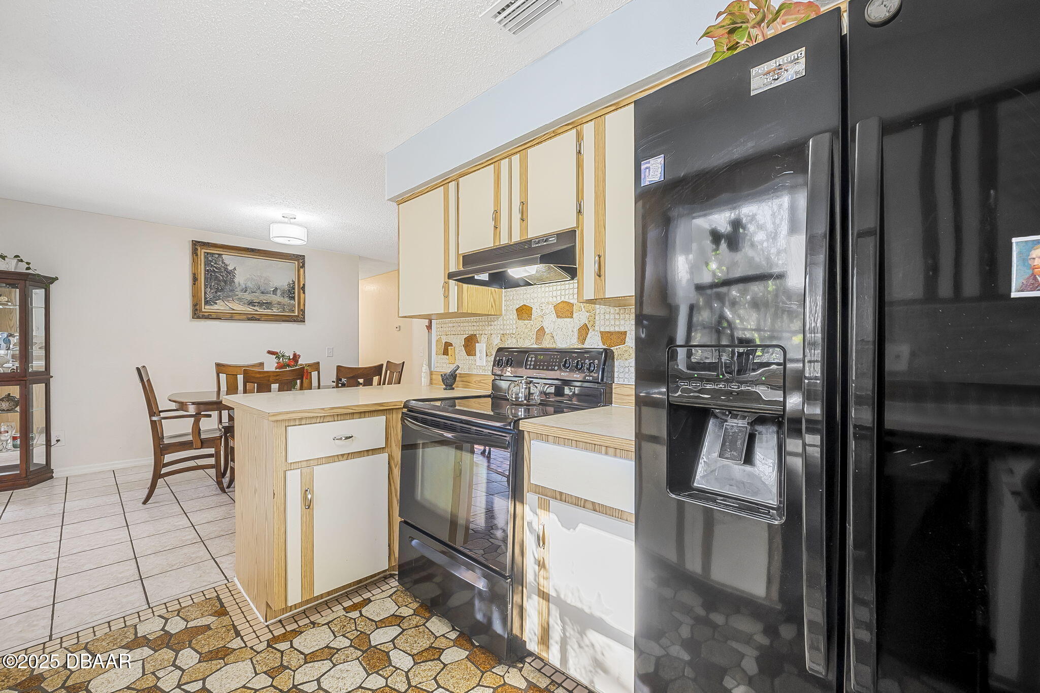 3228 Unity Tree Drive Edgewater, FL 32141 - Photo 11 of 37 a kitchen with stainless steel appliances kitchen island granite countertop a refrigerator and cabinets