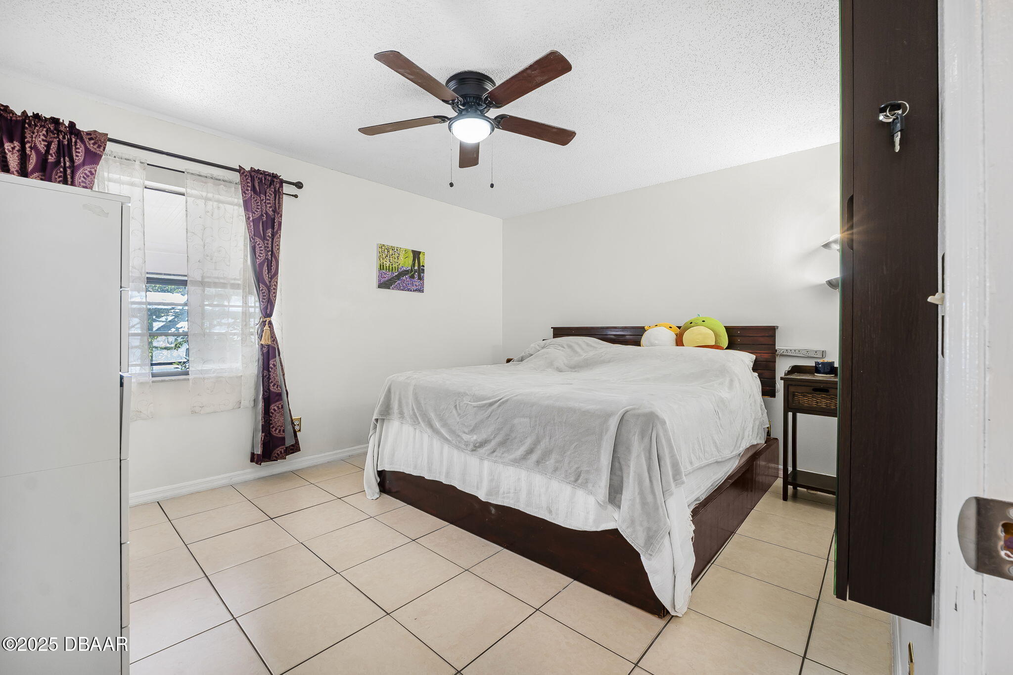 3228 Unity Tree Drive Edgewater, FL 32141 - Photo 12 of 37 a spacious bedroom with a bed and a refrigerator