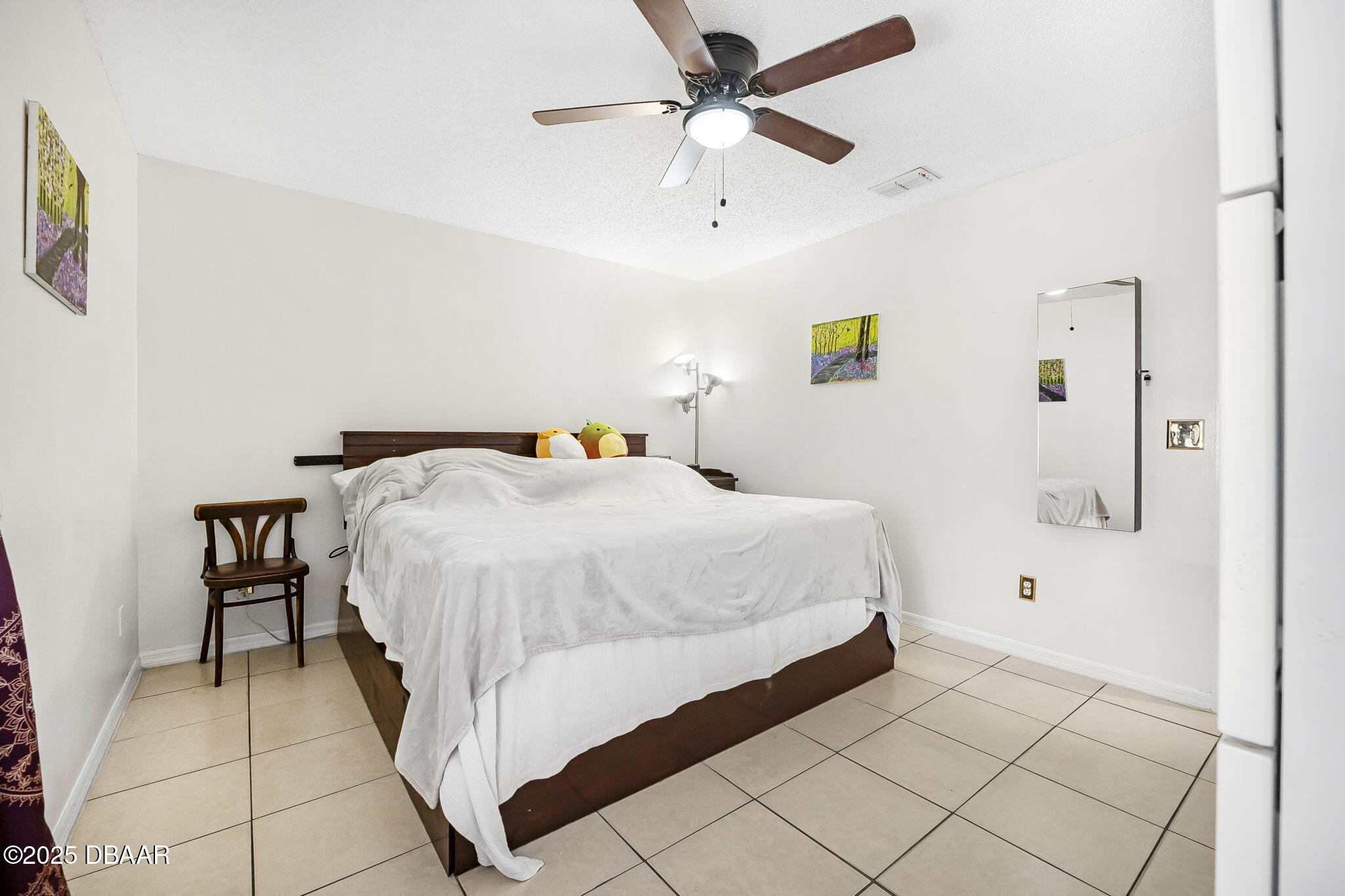 3228 Unity Tree Drive Edgewater, FL 32141 - Photo 13 of 37 a bedroom with a bed and a chandelier