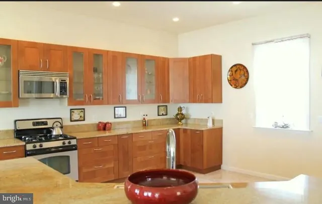 a kitchen with stainless steel appliances granite countertop a refrigerator and a sink