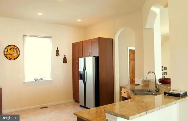 a kitchen with stainless steel appliances granite countertop a stove a sink dishwasher and a microwave oven with wooden cabinets