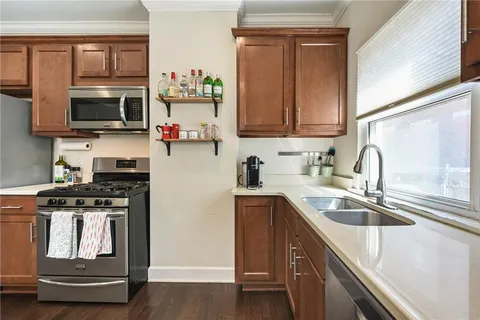a kitchen with stainless steel appliances granite countertop a sink stove and microwave