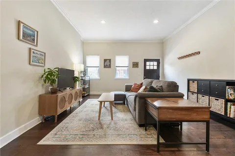a living room with furniture and a wooden floor