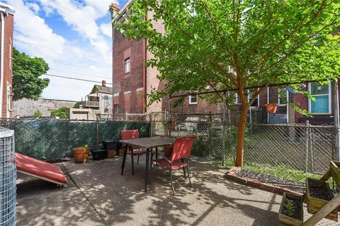 a view of a patio with table and chairs and wooden fence