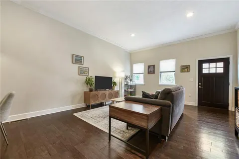 a living room with furniture flat screen tv and window