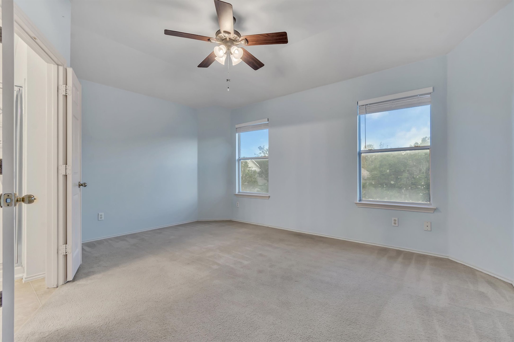 627 Scheel Road Kyle, TX 78640 - Photo 26 of 37 A well-lit bedroom features plush carpeting and multiple windows for abundant natural light.