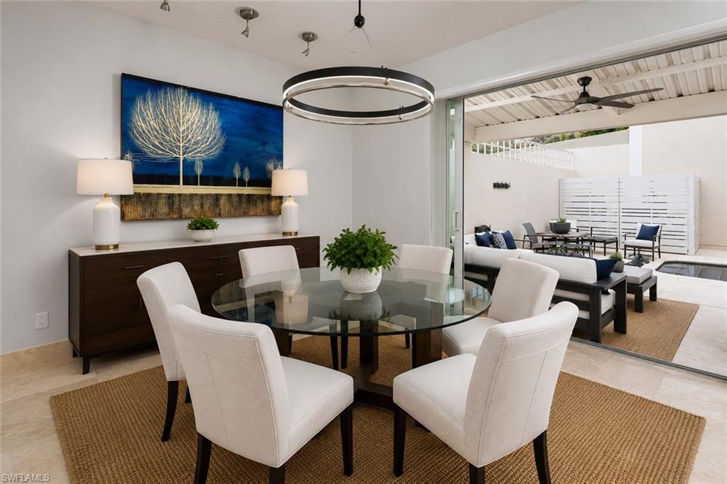 1070 5th Street South Naples, FL 34102 - Photo 6 of 19 a dining room with furniture a chandelier and wooden floor