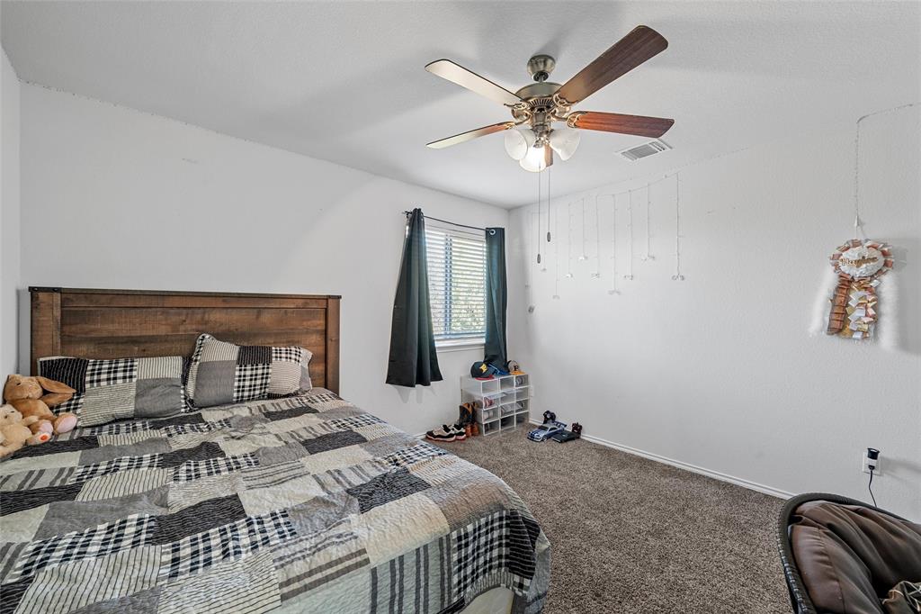 6201 Elephant Butte Drive Waco, TX 76708 - Photo 25 of 40 a bedroom with a large bed and a chandelier