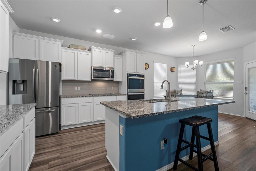 6201 Elephant Butte Drive Waco, TX 76708 - Photo 9 of 40 a kitchen with stainless steel appliances granite countertop a refrigerator a sink dishwasher a stove and white countertops with wooden floor