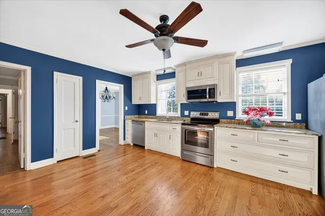 a kitchen with granite countertop a stove cabinets and stainless steel appliances