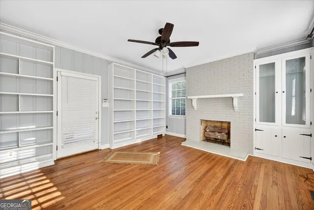 a view of empty room with wooden floor and fireplace