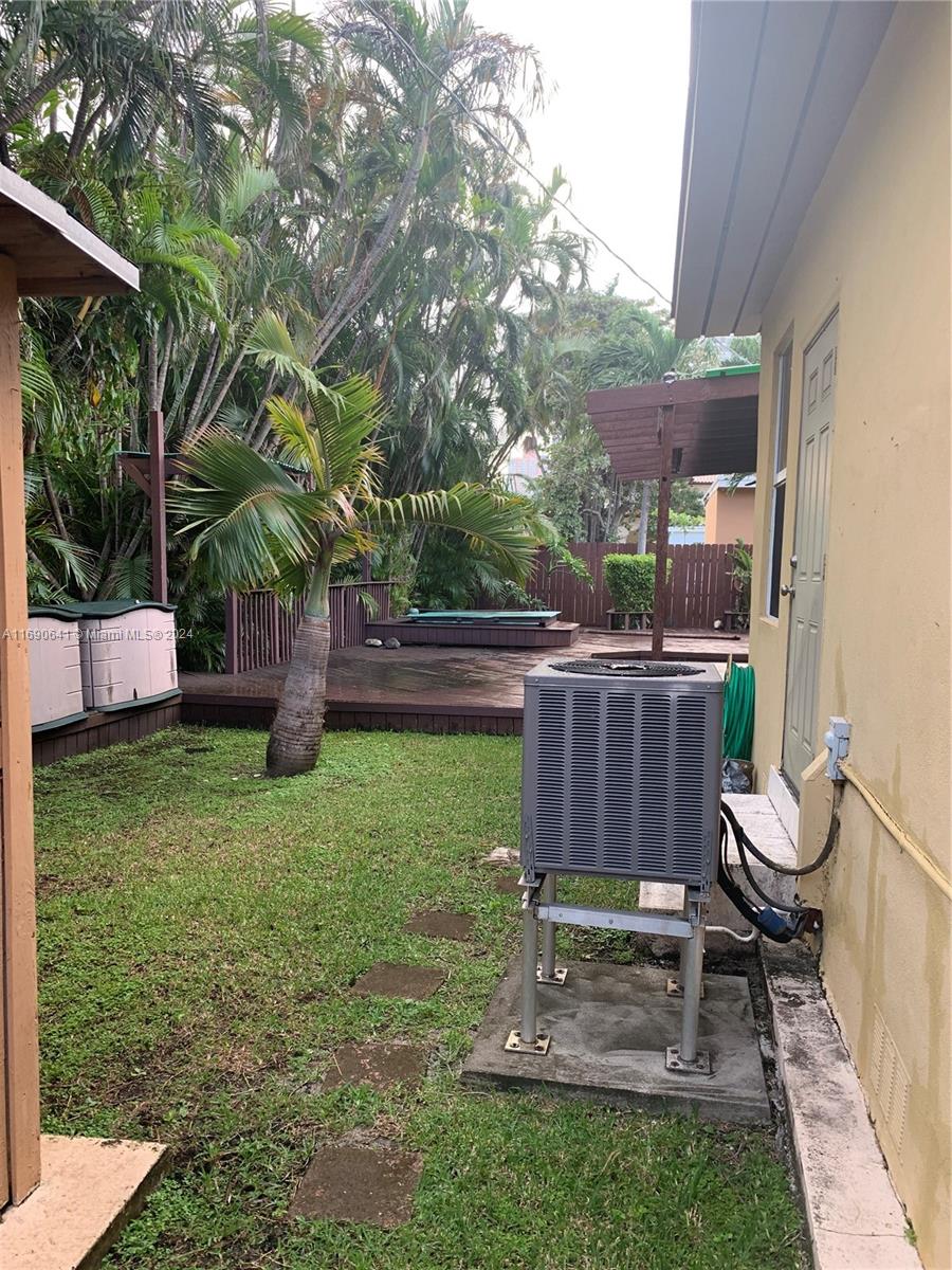 310 191st Terrace Sunny Isles Beach, FL 33160 - Photo 34 of 36 a view of a backyard with chairs potted plants and large tree