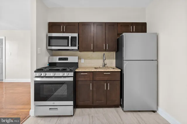 a kitchen with a stove refrigerator and microwave