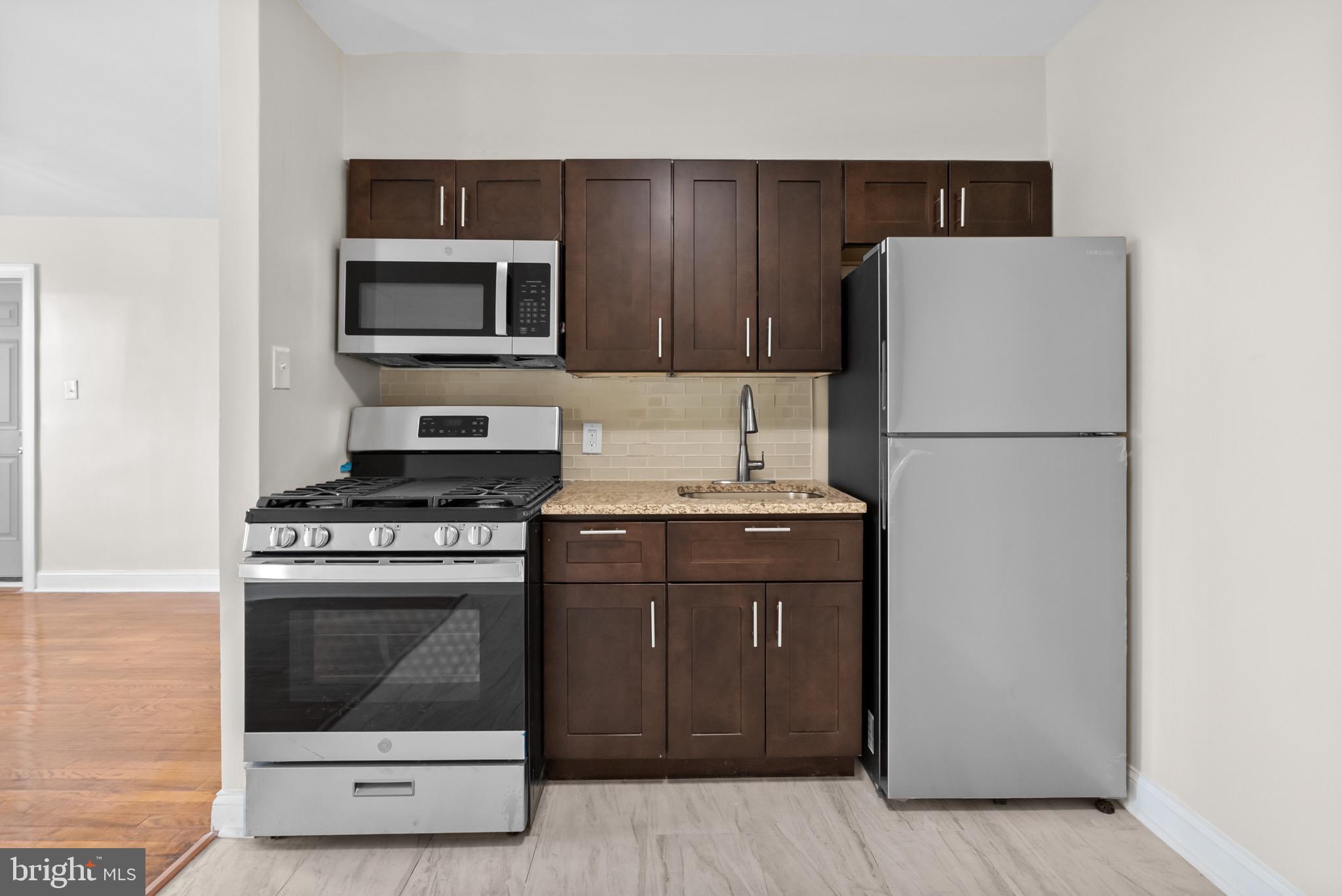 5160 D Street, Unit 2 Philadelphia, PA 19120 - Photo 5 of 23 a kitchen with a stove refrigerator and microwave