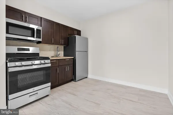 a kitchen with stainless steel appliances a stove a microwave and white cabinets