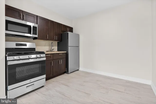 a kitchen with stainless steel appliances a stove a microwave and white cabinets