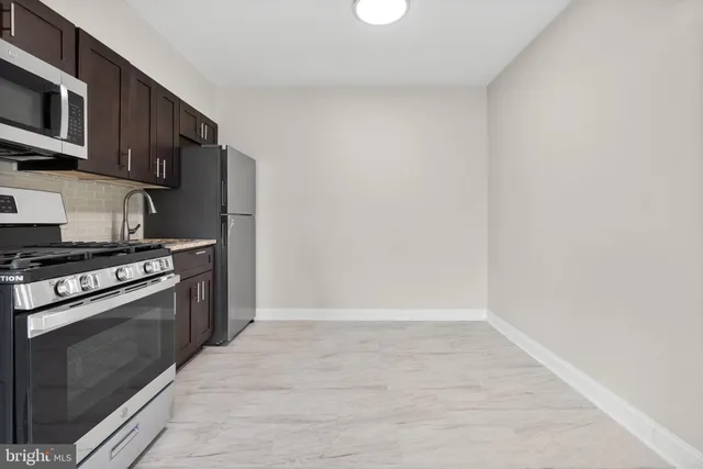 a kitchen with a stove top oven and cabinets